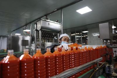 贵州省麻江县明洋食品有限公司酸汤生产车间,工人正在检验灌装酸汤产品(2023年3月17日摄)。新华社发 孙煜 摄